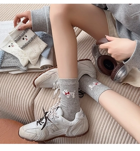 Gros plan d'une broderie de chiot sur des chaussettes grises en coton pour femmes en détail