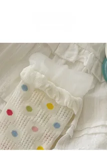 Detail von weißen Netzsocken mit bunten Punkten und Rüschenmanschetten aus Spitze