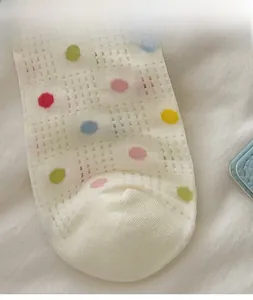 Nahaufnahme weißer atmungsaktiver Netzsocken mit bunten Punkten und hoher Elastizität