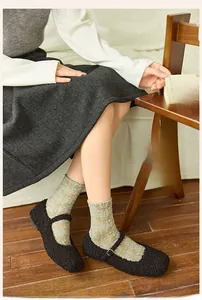 Detail of light green vintage lace crew socks with floral embossed pattern and Mary Janes