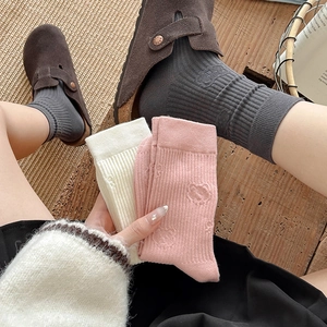 Three pairs of ribbed mid-calf bear socks in pink, beige, and dark grey for women