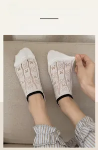 Detail of white mesh low cut socks with black elastic band showing high stretch fabric