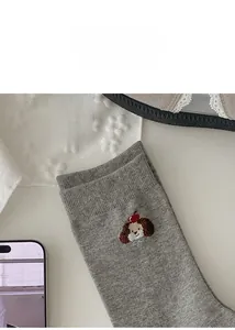 Close-up of grey mid-calf socks featuring exquisite brown cartoon dog embroidery detail