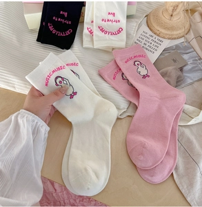 Detail of cute duck embroidery and typography on pink, black and white cotton socks