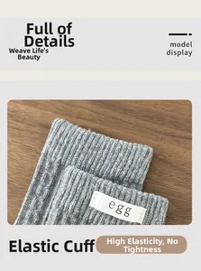 Detail of high-elasticity ribbed cuff on grey knit socks with egg logo textile label