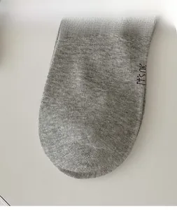 Detail of grey knitted socks featuring dark It's ok embroidery and premium ribbed texture