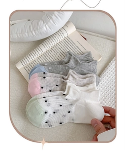 Close-up of five pairs of breathable mesh cotton socks with colorful polka dot patterns