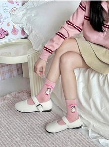Close-up of pink crew socks featuring a cute cartoon duck and MUSIC lettering detail