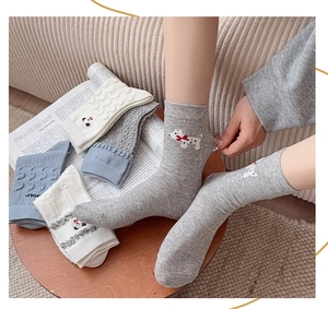 Détail de chaussettes en maille avec broderie de chien et revers ondulés stylés