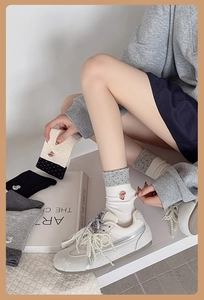 Detail of embroidered puppy motif and polka dot trim on soft cotton mid-calf socks