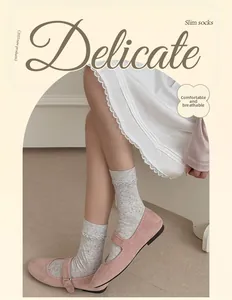 Close-up of light gray mesh socks with delicate frill cuffs and breathable jacquard texture