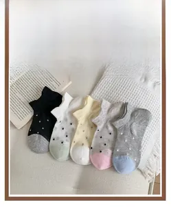 Close-up of five pairs of breathable mesh ankle socks with colorful polka dots