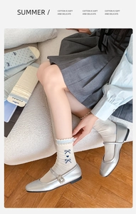 Details von weißen Baumwollsocken mit blauer Schleifenstickerei und Rüschenbündchen
