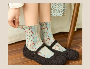 Detail of vintage palace style socks with relief floral patterns and Mary Jane shoes