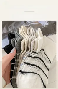 Detail view of elastic ribbed cuffs on striped cotton socks in multiple neutral colors