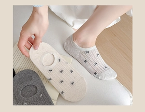 Detail of breathable mesh ankle socks with bow jacquard in cream and grey colors