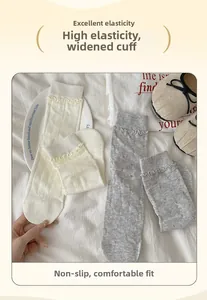 Detail of white cotton socks with heart jacquard pattern and elastic frill cuff trim