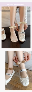 Detail of white lace socks and ballet flats with ribbon bow straps and mesh cutouts