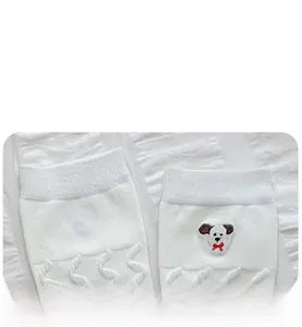 Détail de chaussettes blanches en coton avec broderie de chien et maille torsadée