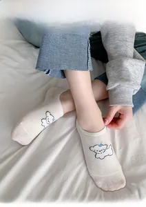 Close-up of white invisible low-cut socks with cute cartoon puppy embroidery details