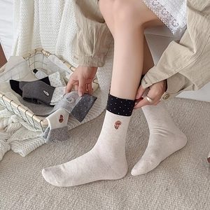 Cozy cotton crew socks featuring cute animal embroidery and polka dot cuffs in neutral tones