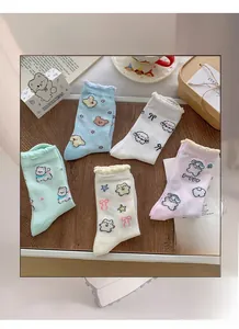 Detail of five pairs of pastel cotton socks with cute puppy patterns and ruffled edges