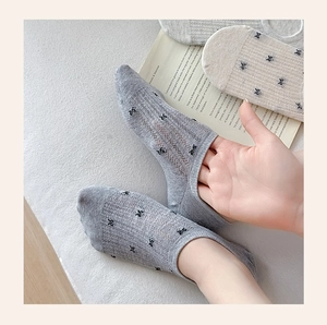 Detail of mesh invisible socks with bow pattern and breathable mesh texture for women