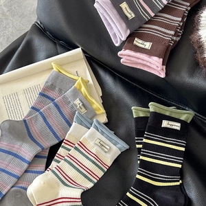 Retro gestreifte Socken mit Happiness Stoffetikett auf dunklem Lederhintergrund