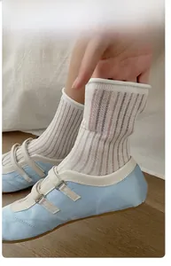 Close-up of cream mesh crew socks with elastic texture paired with ballet flat shoes