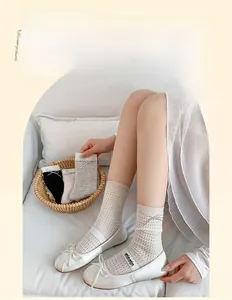 Detailed view of hollow knit mesh socks with elegant ribbon bow accents for women