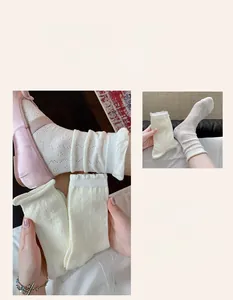Detail of white knit lace crew socks with hollow diamond texture and ruffle cuffs