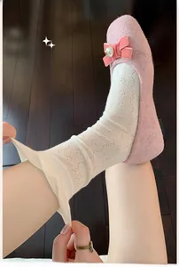 Detail of white floral lace crew socks showing elastic fabric and breathable hollow texture