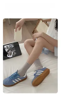 Close-up of cream mesh crew socks paired with blue retro suede sneakers on white sheets