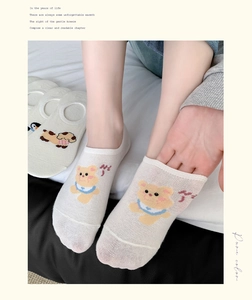 Close-up of white invisible socks with cute cartoon bear pattern and breathable cotton fabric