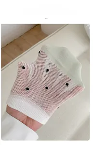 Detail of high elasticity mesh on polka dot summer socks being stretched by hand