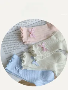 Close-up of pastel mesh crew socks featuring ruffled edges and plaid bow details