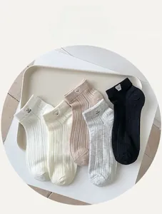 Detail of five pairs of cotton mesh socks with cute bear embroidery and ribbed texture