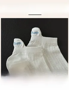 Detail einer weißen Baumwollsocke mit Puppy-Stickerei am gerippten elastischen Bündchen