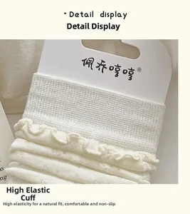Detailed close-up of the ruffled cuff and knit texture on cream-colored cotton socks