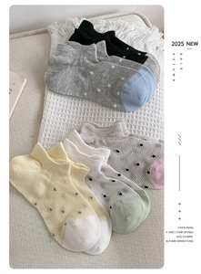 Detail of five pairs of breathable mesh socks with polka dots in mixed colors