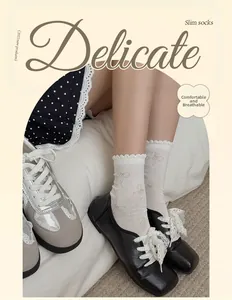 Close-up of white mesh socks with delicate bow patterns and ruffled lace trim edges