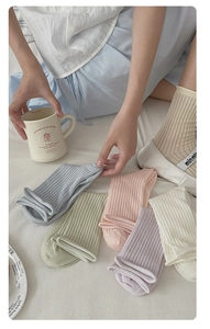 Detailed close-up of macaron color ribbed cotton socks in a cozy home setting