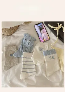 Detail of five assorted blue and white mid-calf socks with heart and bow embroidery