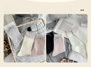 Detailed close-up of pointelle knit socks with delicate bows in four neutral colors