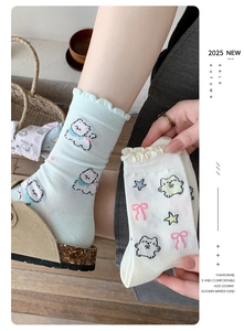 Detail of cute knitted mid-calf socks featuring wavy frill cuffs and cartoon cat patterns