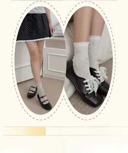Detail of bow embroidery and ruffled cuffs on white and grey cotton mid-tube socks