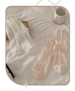 Detail of breathable heart hollow-out knit patterns on pink and white crew socks