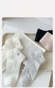 Detailed view of ribbed cotton socks with bear embroidery in a set of neutral colors