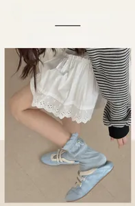 Detail of light blue ruffled socks with white bows and vertical knitted stripes for girls