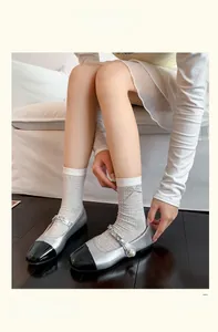 Detail of Mary Jane shoes with chain pearls and plaid socks with leather bows